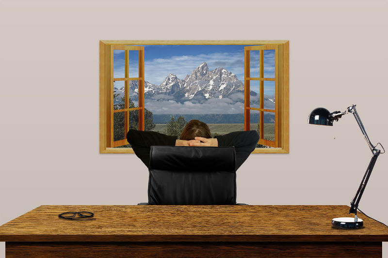 Бизнесмен сидит за столом перед открытым окном - фото